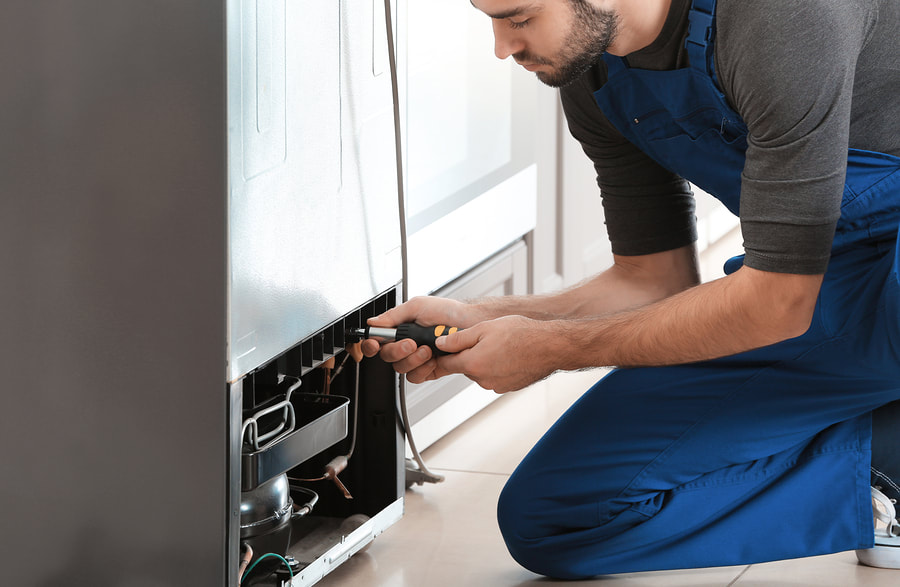 handyman doing fridge repair