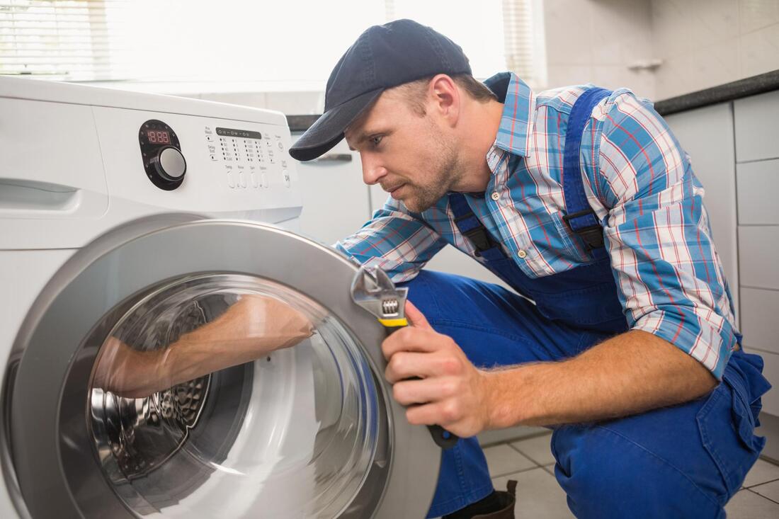 repair man looking at dryer
